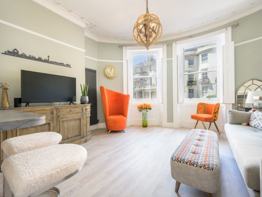 Lansdowne Place | Sitting Room with orange chairs and TV